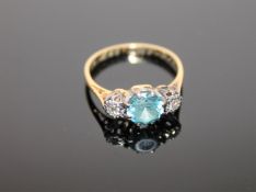 An 18ct gold blue zircon and diamond three stone ring, size L.