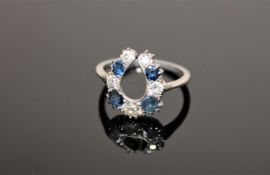 An antique platinum horseshoe ring, set with sapphires and old cut diamonds,