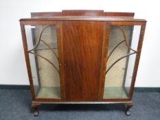 A mahogany side by side display cabinet on claw and ball feet