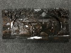 A carved Eastern plaque depicting figures harvesting