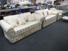 Three piece Delcor lounge suite in cream and gold fabric with scatter cushions and a footstool