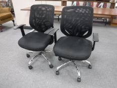 Two black mesh swivel office armchairs