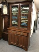A Victorian and later glazed bookcase with cabinet below 'Charles Baker Haberdasher',