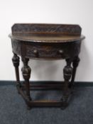 A heavily carved early 20th century oak hall table CONDITION REPORT: The top is not