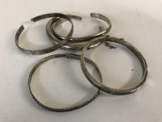 Five silver / white metal bangles.