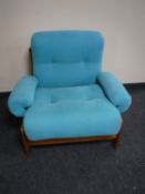 A mid 20th century teak framed armchair in turquoise covering