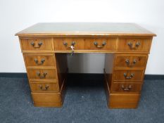A yew wood twin pedestal writing desk with green leather inset panel
