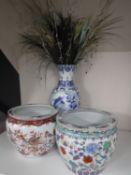 Two oriental fish bowl planters and an blue and white vase with bird decoration containing dried