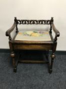 An Edwardian oak storage piano stool CONDITION REPORT: Slight wobble to the frame