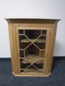 A pine glazed door hanging corner cupboard