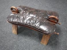 A 20th century camel stool with button leather cushion