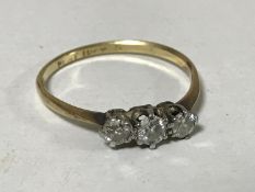 An 18ct gold three stone diamond ring, size N/O, 1.5g.