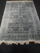 A machine made fringed Persian rug on turquoise ground
