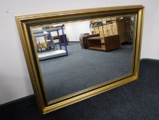 A black and gilt framed bevel edge mirror