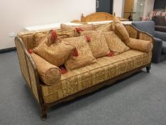 A 20th century French day bed upholstered in a classical print and a quantity of cushions in the