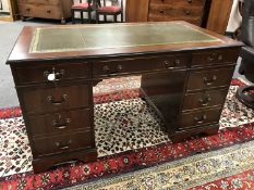 A reproduction mahogany pedestal desk with green leather insert,
