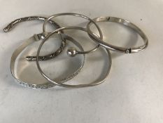 Five silver / white metal bangles.