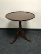 A mahogany pie crust edge tilt topped table on three way pedestal
