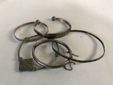 Five silver / white metal bangles.