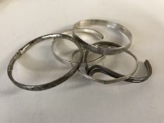 Five silver / white metal bangles.