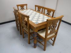 A pine tiled topped kitchen table and six pine chairs plus a matching side table