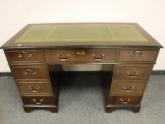 A reproduction mahogany pedestal desk with leather inset top,