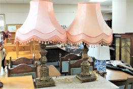 A pair of ornate brass table lamps with shades