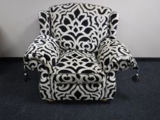 A contemporary armchair in black and white swirl fabric
