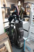A McGregor golf bag containing assorted irons and drivers, folding golf trolley,