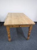 A pine farmhouse kitchen table fitted a drawer