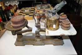 A vintage set of scales with weights and a brass blow torch