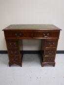 A twin pedestal leather topped desk fitted eight drawers