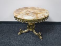 A circular onyx topped coffee table on three-way brass base