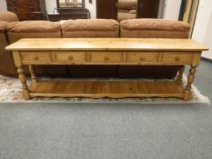 An antique pine style serving table fitted five drawers, width 244 cm.