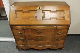 An oak serpentine fronted bureau,