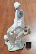 A Lladro figure of a lady seated on a tree branch