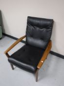 A mid 20th century teak framed black vinyl armchair