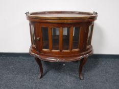 A reproduction mahogany oval drinks cabinet with lift off tray