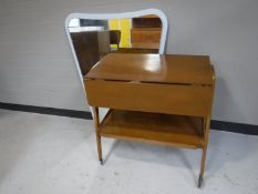 A mid 20th century drop leaf trolley and a mirror mounted on board