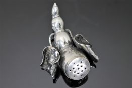 An Oriental white metal pounce pot in the form of a segmented scorpion tail amid lotus leaves.