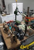 A small collection of desk top power tools, bench top drill, two presses, small desktop grinder,