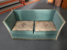 A mid twentieth century turquoise upholstered drop end two seater settee