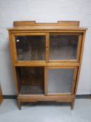 An Edwardian oak glazed shutter door cabinet