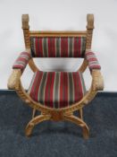 A carved oak X-framed chair in stripped fabric