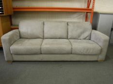 A grey suede three seater settee