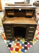 An early twentieth century oak roll top desk