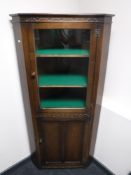 A carved oak corner cabinet
