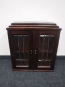 A mahogany double door glazed cabinet with key