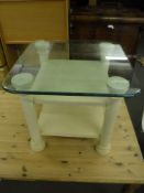 A contemporary glass topped pedestal table