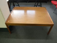 A contemporary teak low coffee table